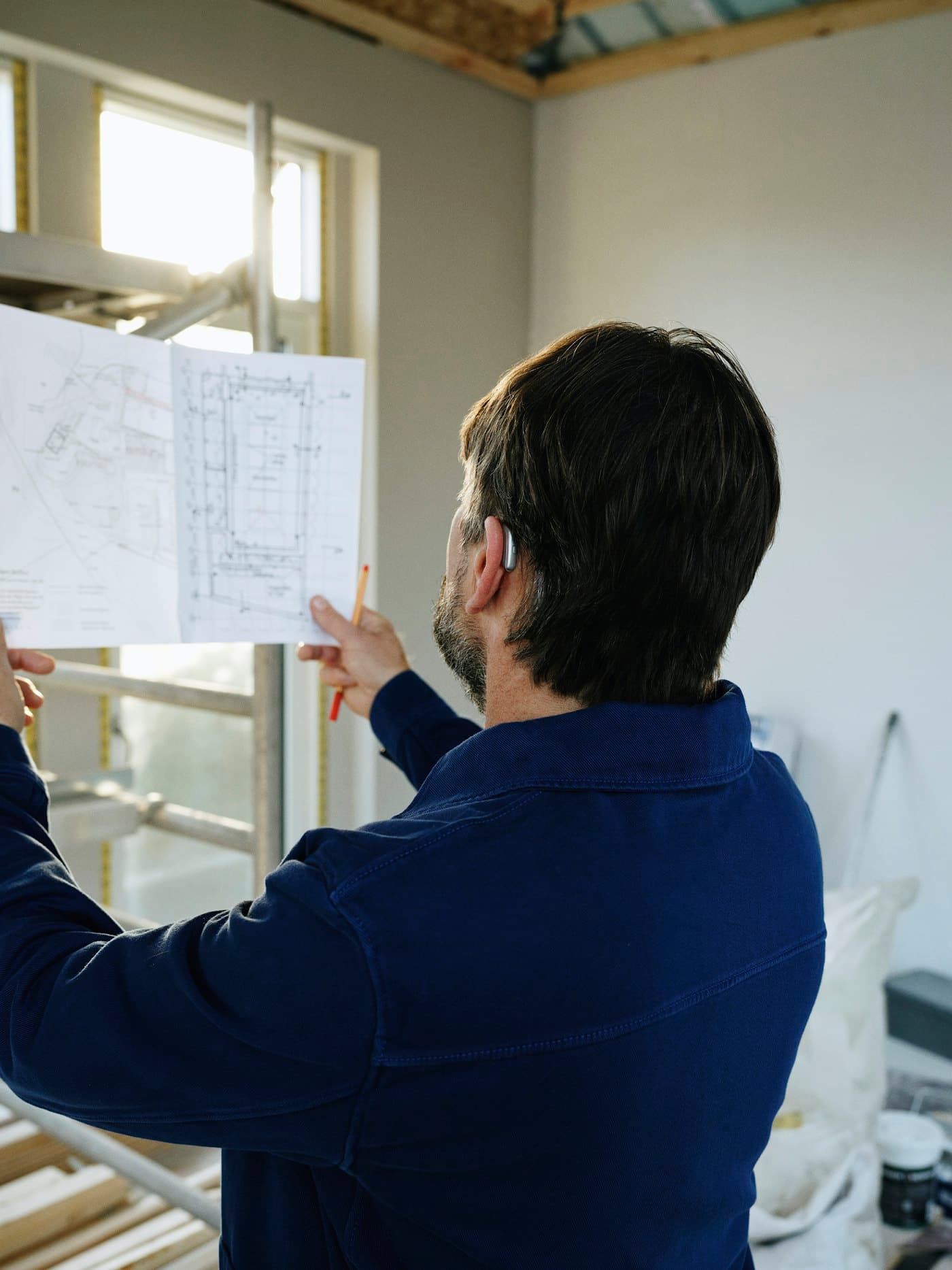 Team member reviewing renovation drawings on site